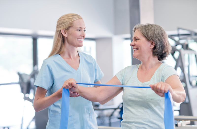 Female physiotherapist assisting an older patient during a treatment session